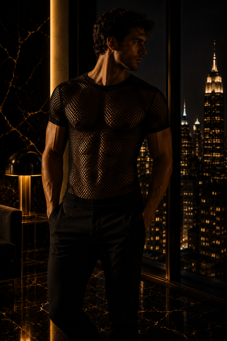 Mann in einem schwarzen Netzshirt vor einer luxuriösen Fensterfront bei Nacht. Warme Goldtöne, schwarzer Marmorboden und die beleuchtete Skyline schaffen eine elegante, moderne und maskuline Fashion-Atmosphäre.