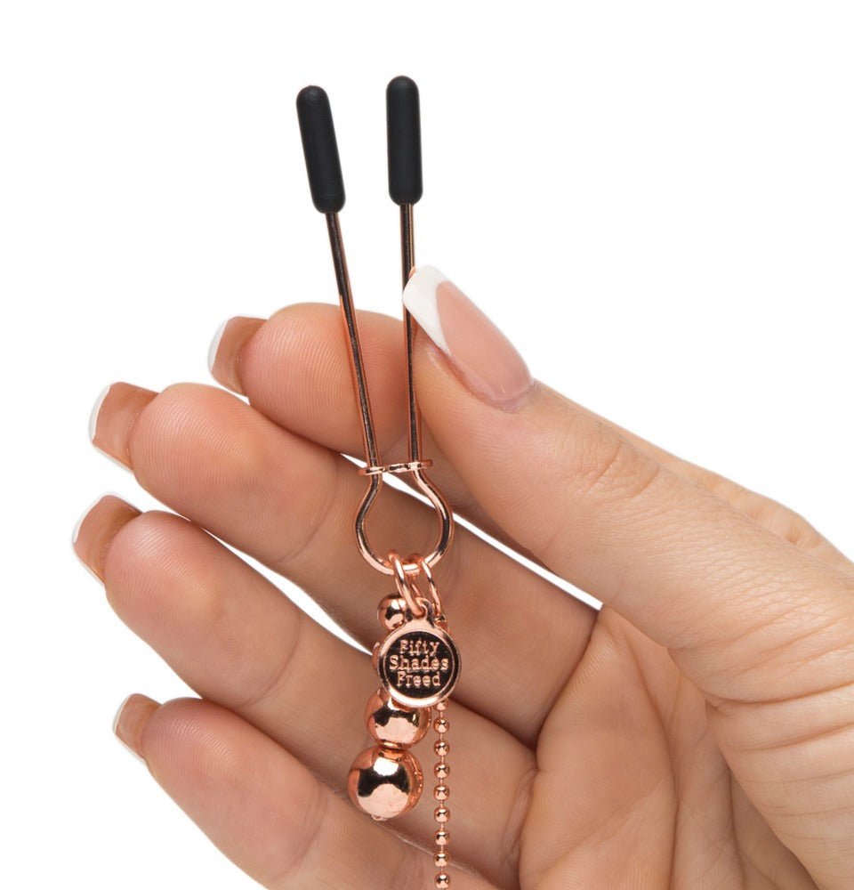 Detailaufnahme eines roségoldenen Ketten-Harness in der Hand gehalten