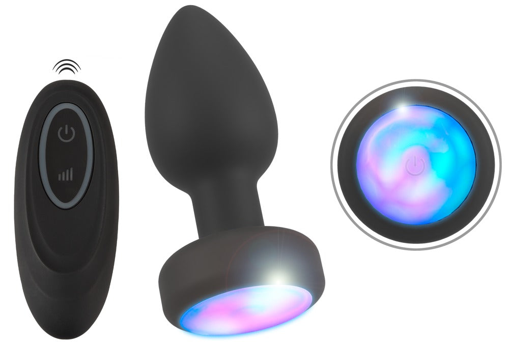 ANOS LED Analplug in Schwarz – Produktübersicht mit Fernbedienung und Detailansicht der mehrfarbig beleuchteten LED-Basis