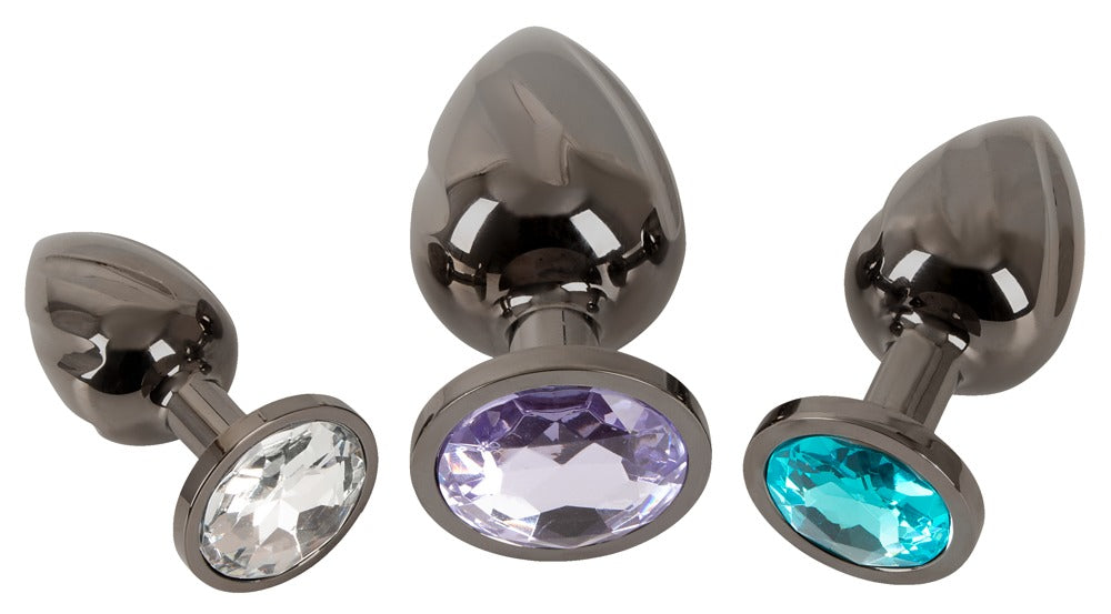 ANOS Metall-Analplug-Set – liegende Produktansicht mit silberfarbenen Metallkörpern und farbigen Schmucksteinen