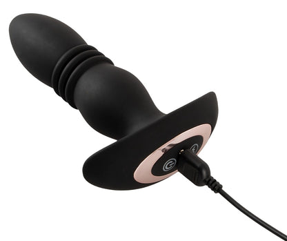 ANOS Prostata-Massager in Schwarz – liegende Produktansicht mit strukturierter Form, geschwungener Basis und angeschlossenem Ladekabel