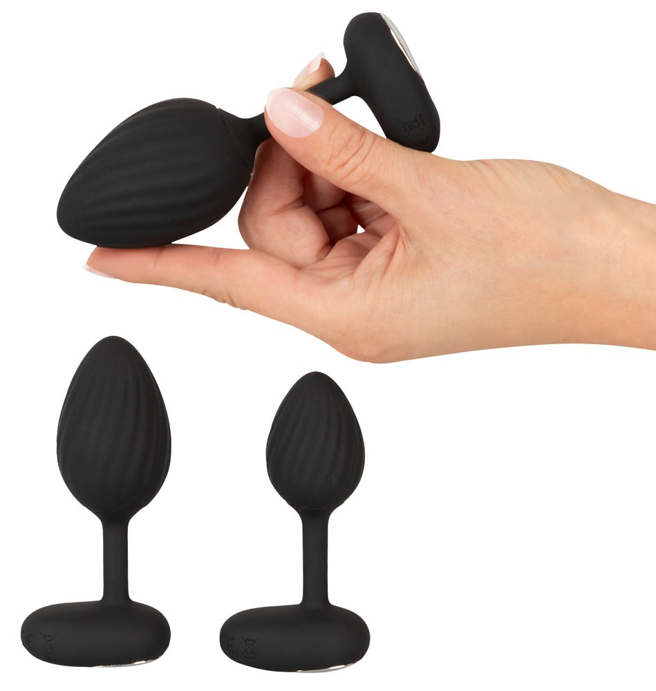ANOS Vibro-Analplug-Set – Größenvergleich der drei schwarzen Analplugs in einer Hand