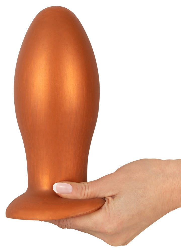 ANOS XL Analplug aus Liquid Silicone in Orange – auf einer Hand stehende Produktansicht zur Darstellung der XL-Größe