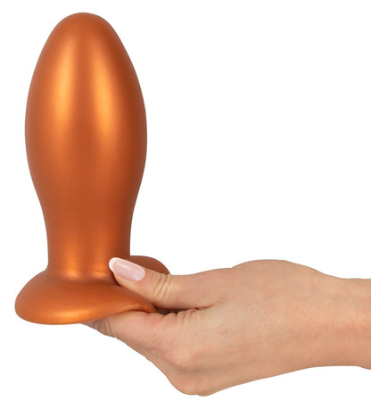 ANOS XL Analplug aus Liquid Silicone in Orange – stehende Seitenansicht mit abgerundeter Spitze und breiter Saugbasis