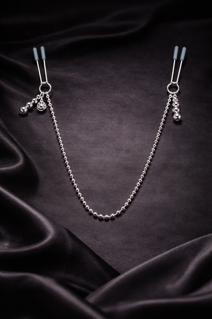 Elegante Nippelklemmenkette in Schwarz und Silber auf dunklem Stoff stilvoll drapiert