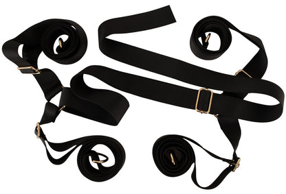 Ausgebreitetes schwarzes Gurtkreuz des Bad Kitty Bettfessel-Sets Deluxe mit Metallringen