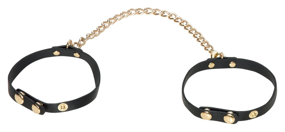 Schwarze Fußfesseln mit goldfarbener Verbindungskette aus dem Bad Kitty Bondage-Set