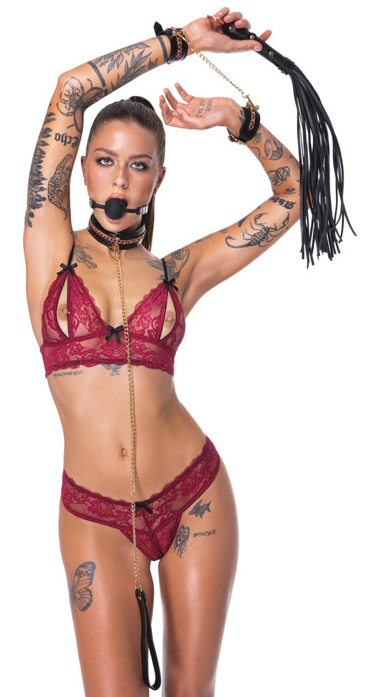Model mit dem Bad Kitty Bondage-Set 6-teilig mit Knebel und Flogger mit erhobenen Armen