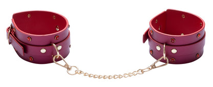 Pinkfarbene Handfesseln mit goldfarbener Verbindungskette aus dem Bad Kitty Bondage-Set