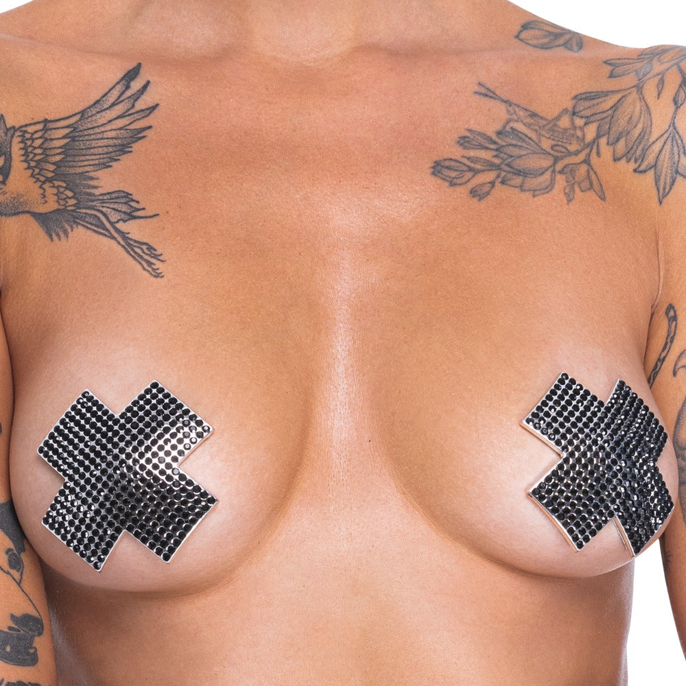Detailansicht der schwarzen Cottelli ACCESSOIRES Nipple Sticker Cross auf der Haut