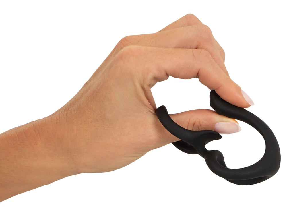 Erecto Cock & Ball Ring bei der Dehnungsdemonstration in der Hand mit elastischen verbundenen Ringen