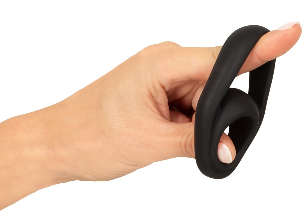 Erecto Cock & Ball Ring in der Hand zur Darstellung des weichen und flexiblen schwarzen Liquid-Silikons