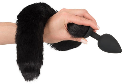 Bad Kitty Pet Play Plug & Ears flauschiger schwarzer Katzenschwanz mit Analplug, leicht gebogen und in einer Hand gehalten in alternativer Detailansicht – erhältlich bei Evoria Care