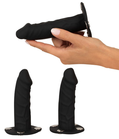 Bad Kitty Strap-on-String Zubehör mit drei schwarzen Silikon-Dildos unterschiedlicher Form, einer davon in einer Hand gehalten zur Veranschaulichung von Größe und Handhabung – erhältlich bei Evoria Care