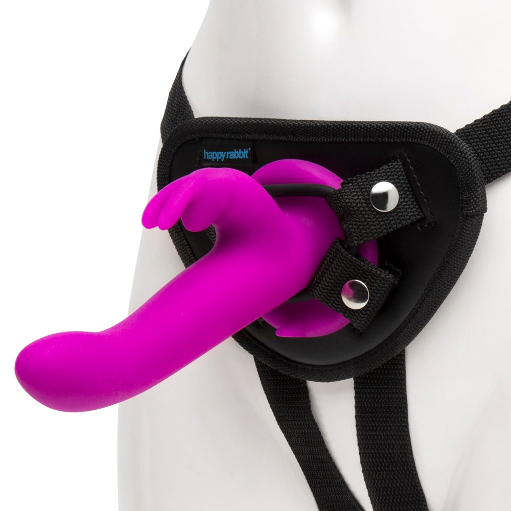 Happy Rabbit Vibrating Strap-On – Frontansicht des schwarzen Strap-on-Harness mit eingesetztem pinkfarbenem Rabbitvibrator – erhältlich bei Evoria Care
