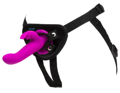 Happy Rabbit Vibrating Strap-On – schräge Ansicht des schwarzen Harness mit pinkfarbenem Rabbitvibrator und verstellbaren Riemen – erhältlich bei Evoria Care