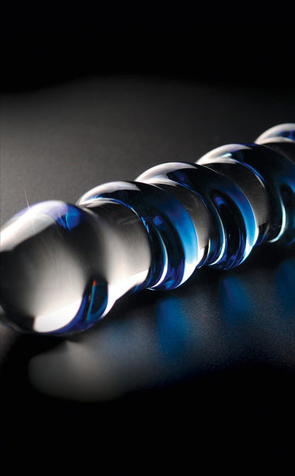 Icicles No. 5 Premium-Glasdildo mit transparenter Glasoberfläche und spiralförmig verlaufenden blauen Erhebungen in diagonaler Detailansicht vor schwarzem Hintergrund – erhältlich bei Evoria Care