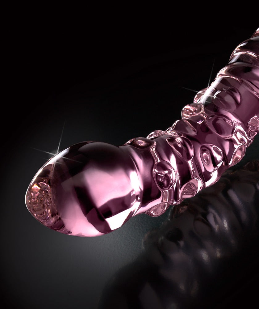 Icicles No. 55 doppelseitiger Glasdildo in Pink mit geschwungener Form, ausgeprägter Oberflächenstruktur und glatten Enden in diagonaler Detailansicht vor schwarzem Hintergrund – erhältlich bei Evoria Care