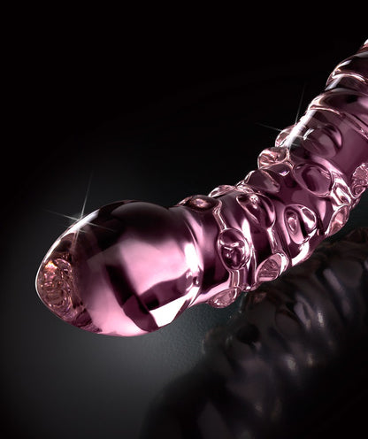 Icicles No. 55 doppelseitiger Glasdildo in Pink mit geschwungener Form, ausgeprägter Oberflächenstruktur und glatten Enden in diagonaler Detailansicht vor schwarzem Hintergrund – erhältlich bei Evoria Care