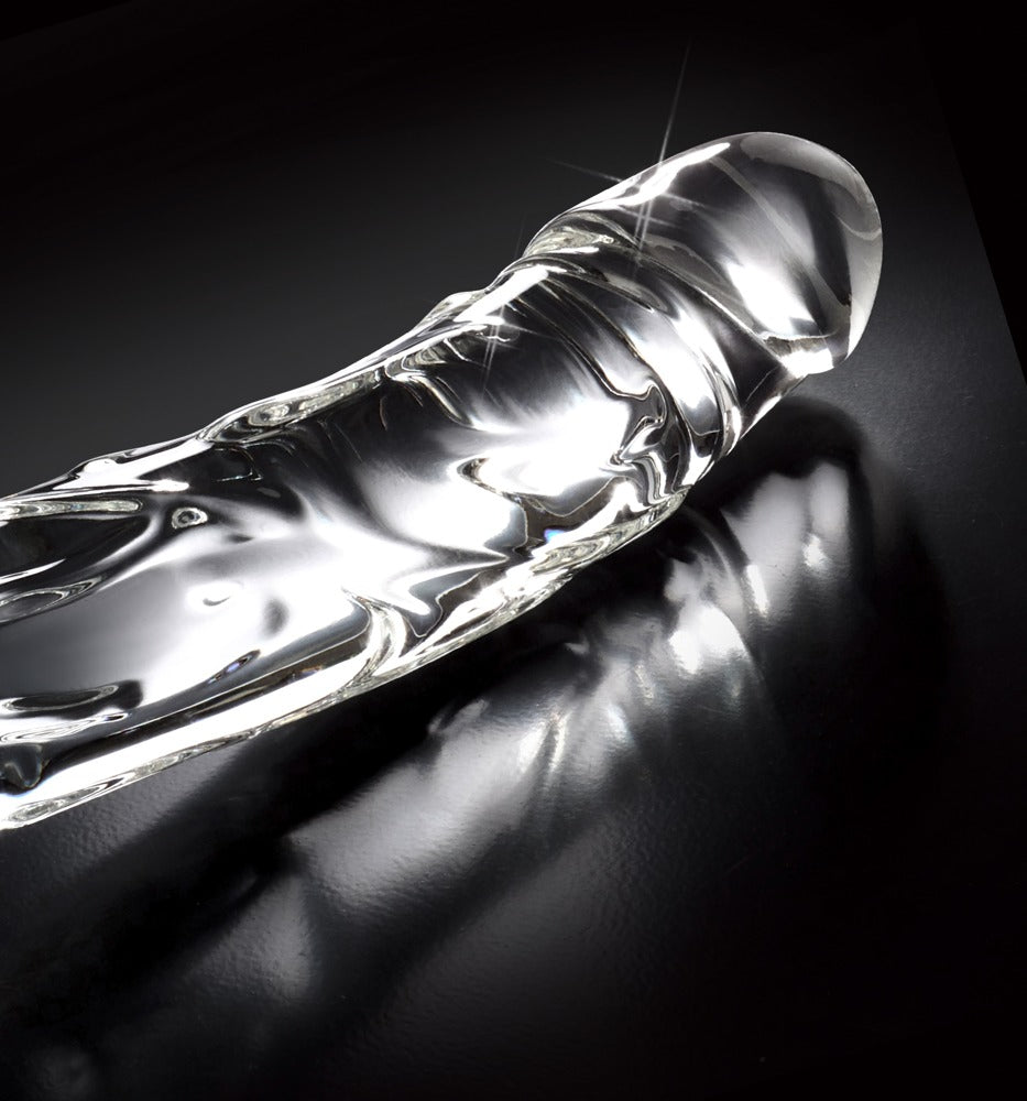 Icicles No. 62 transparenter Premium-Glasdildo mit realistischer Oberflächenstruktur, ausgeformter Eichel und gebogenem Schaft in diagonaler Detailansicht vor schwarzem Hintergrund – erhältlich bei Evoria Care