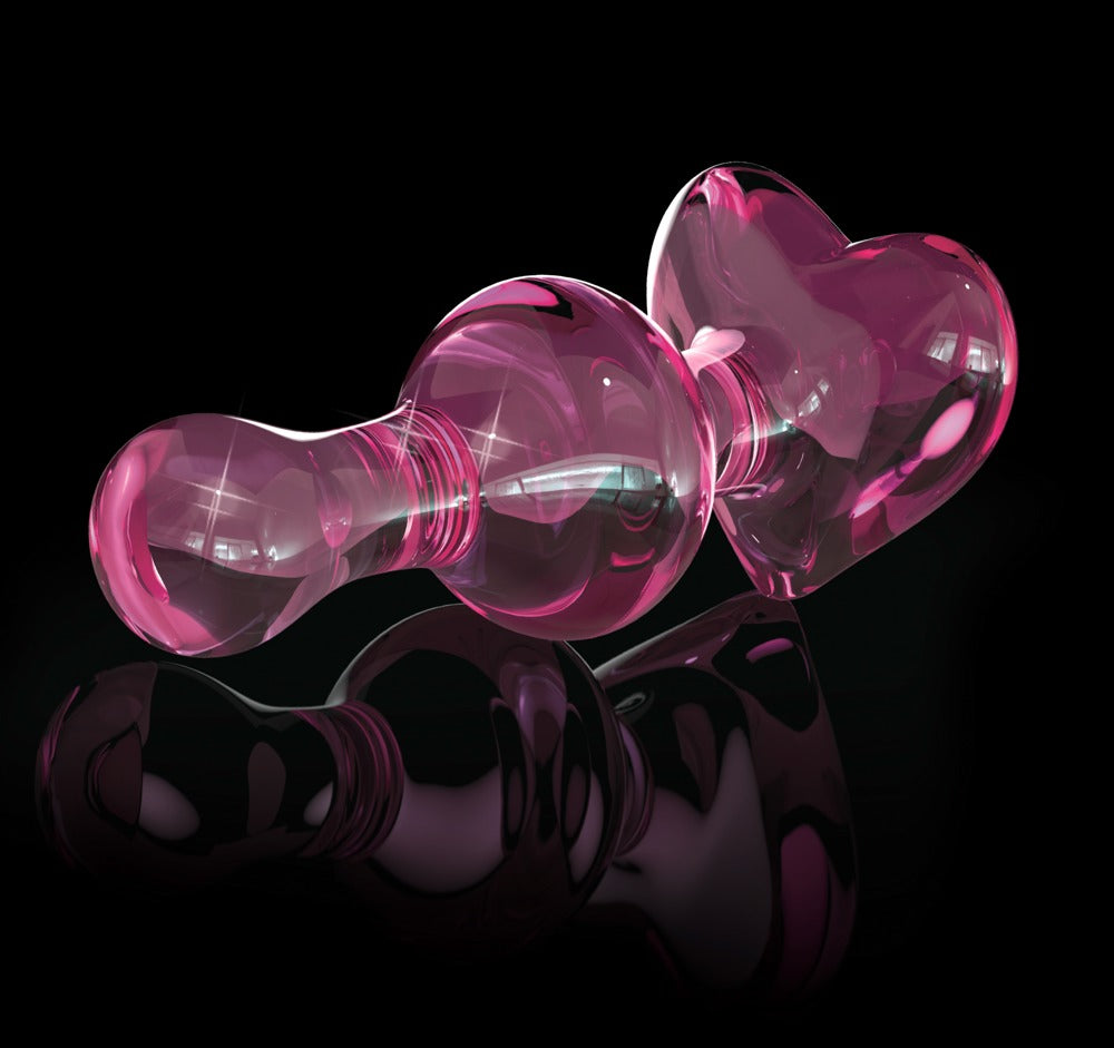 Icicles No. 75 Glas-Analplug in transparentem Pink mit dekorativer Herzbasis, inszeniert vor schwarzem Hintergrund mit reflektierenden Lichtakzenten – erhältlich bei Evoria Care