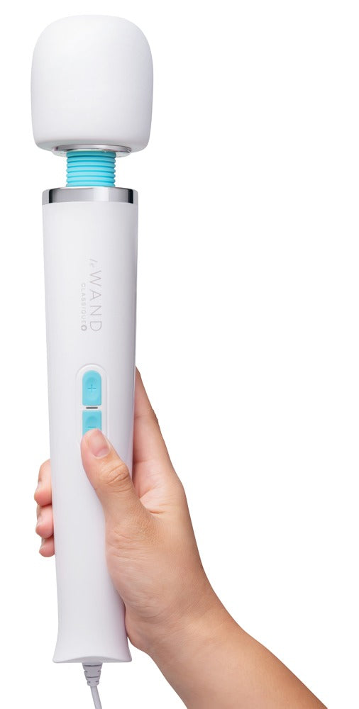 le WAND Classique Plug-In Massagestab in Weiß, aufrecht in einer Hand gehalten zur Veranschaulichung von Größe und Handhabung – erhältlich bei Evoria Care