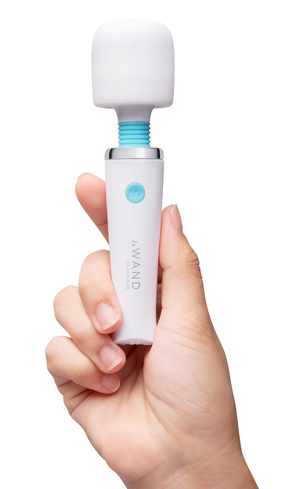 le WAND Classique Mini Massagestab in Weiß, aufrecht in einer Hand gehalten zur Veranschaulichung von Größe und Handhabung – erhältlich bei Evoria Care