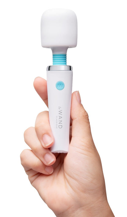 le WAND Classique Mini Massagestab in Weiß, aufrecht in einer Hand gehalten zur Veranschaulichung von Größe und Handhabung – erhältlich bei Evoria Care