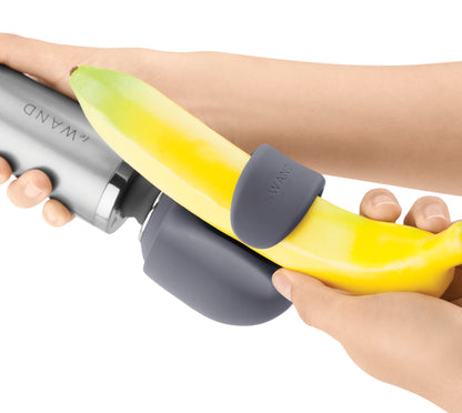 Le Wand Loop Silikonaufsatz in Grau mit flexibler ovaler Öffnung, bei einer Handhabungsdemonstration mit gelbem Hilfsobjekt zur Veranschaulichung der Dehnbarkeit – erhältlich bei Evoria Care