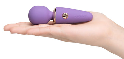 le WAND Mini Microwand lilafarbener Mini-Massagestab auf einer ausgestreckten Hand zur Veranschaulichung seiner kompakten Größe – erhältlich bei Evoria Care