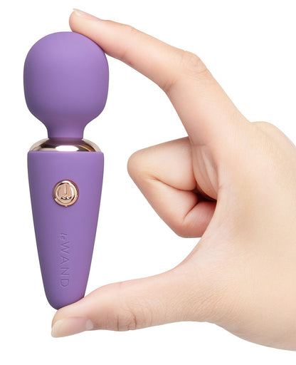 le WAND Mini Microwand in Lila mit goldfarbenen Bedientasten, aufrecht in einer Hand gehalten zur Darstellung von Größe und Handhabung – erhältlich bei Evoria Care