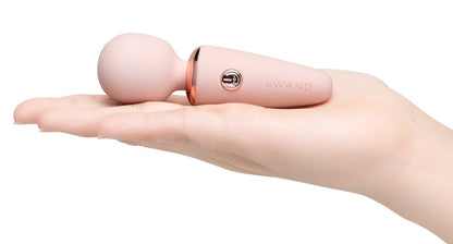 le WAND Mini Microwand rosafarbener Mini-Massagestab auf einer ausgestreckten Hand zur Veranschaulichung seiner kompakten Größe – erhältlich bei Evoria Care