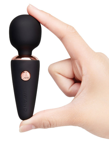 le WAND Mini Microwand in Schwarz mit roségoldfarbenen Bedientasten, aufrecht in einer Hand gehalten zur Darstellung der Handhabung – erhältlich bei Evoria Care