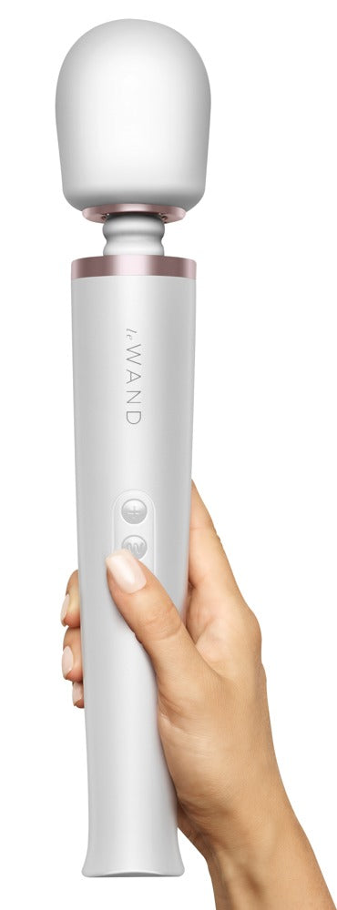 le WAND Original weißer Premium-Massagestab mit silberfarbenem Zierring, aufrecht in einer Hand gehalten zur Veranschaulichung von Größe und Handhabung – erhältlich bei Evoria Care