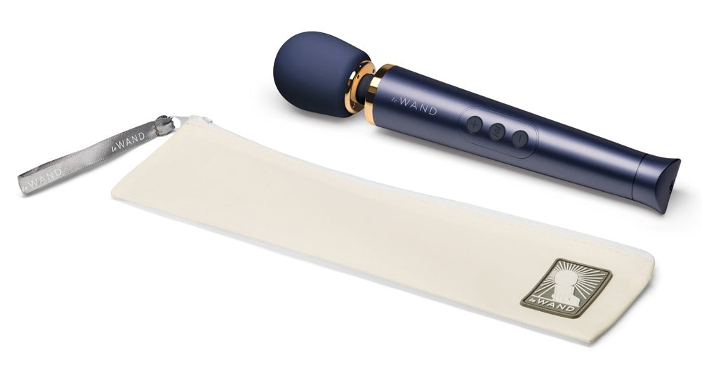 le WAND Petite Wand Massager in metallischem Dunkelblau mit goldfarbenen Akzenten neben einer weißen Aufbewahrungstasche – erhältlich bei Evoria Care