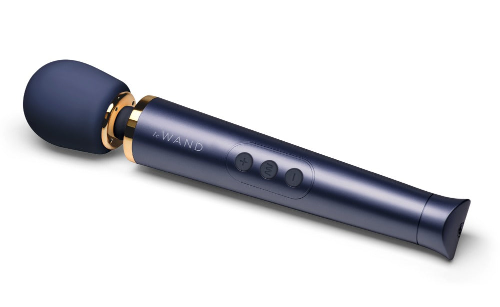 le WAND Petite Wand Massager in metallischem Dunkelblau mit goldfarbenem Zierring, rundem Massagekopf und schlankem Griff in diagonaler Produktansicht – erhältlich bei Evoria Care