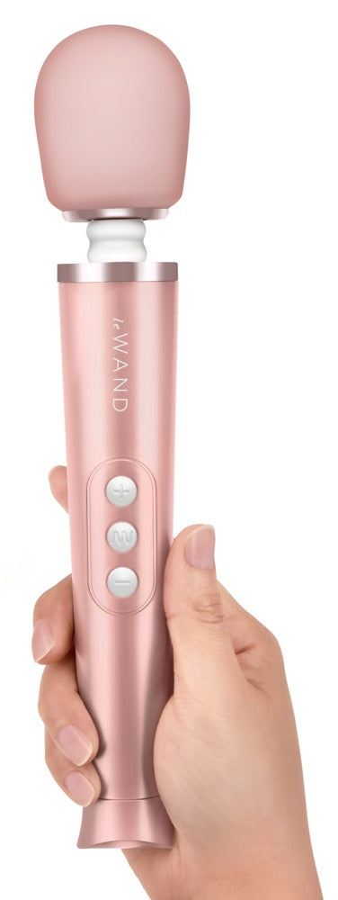 le WAND Petite roségoldfarbener Massagestab mit rosafarbenem Massagekopf, aufrecht in einer Hand gehalten zur Veranschaulichung von Größe und Handhabung – erhältlich bei Evoria Care