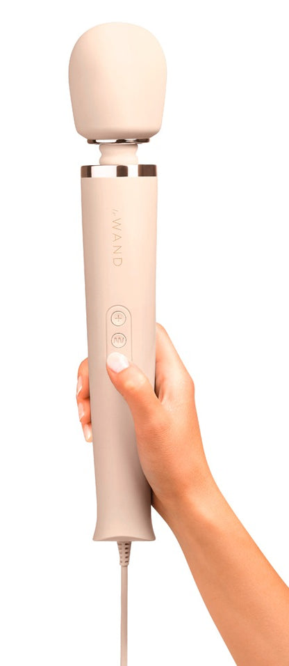 le WAND Powerful Plug-In Massagestab in Champagner mit roségoldfarbenen Details, aufrecht in einer Hand gehalten zur Veranschaulichung von Größe und Handhabung – erhältlich bei Evoria Care