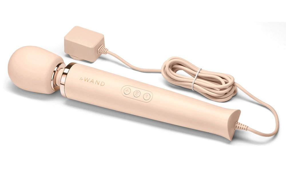le WAND Powerful Plug-In Wand Massager in Champagner mit rundem Massagekopf, sichtbarem Anschlusskabel und Zubehör in horizontaler Produktansicht – erhältlich bei Evoria Care