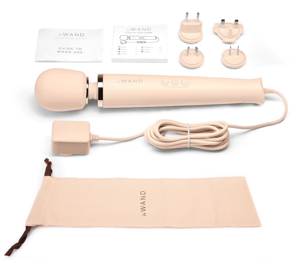 le WAND Powerful Plug-In Luxus-Massagestab in Champagner mit verschiedenen Massageaufsätzen, Anschlusskabel und beigefarbenem Aufbewahrungszubehör – erhältlich bei Evoria Care