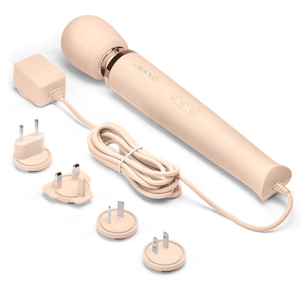le WAND Powerful Plug-In Massagestab in Champagner mit roségoldfarbenen Akzenten und mehreren abgebildeten Massageaufsätzen in einer Produktübersicht – erhältlich bei Evoria Care