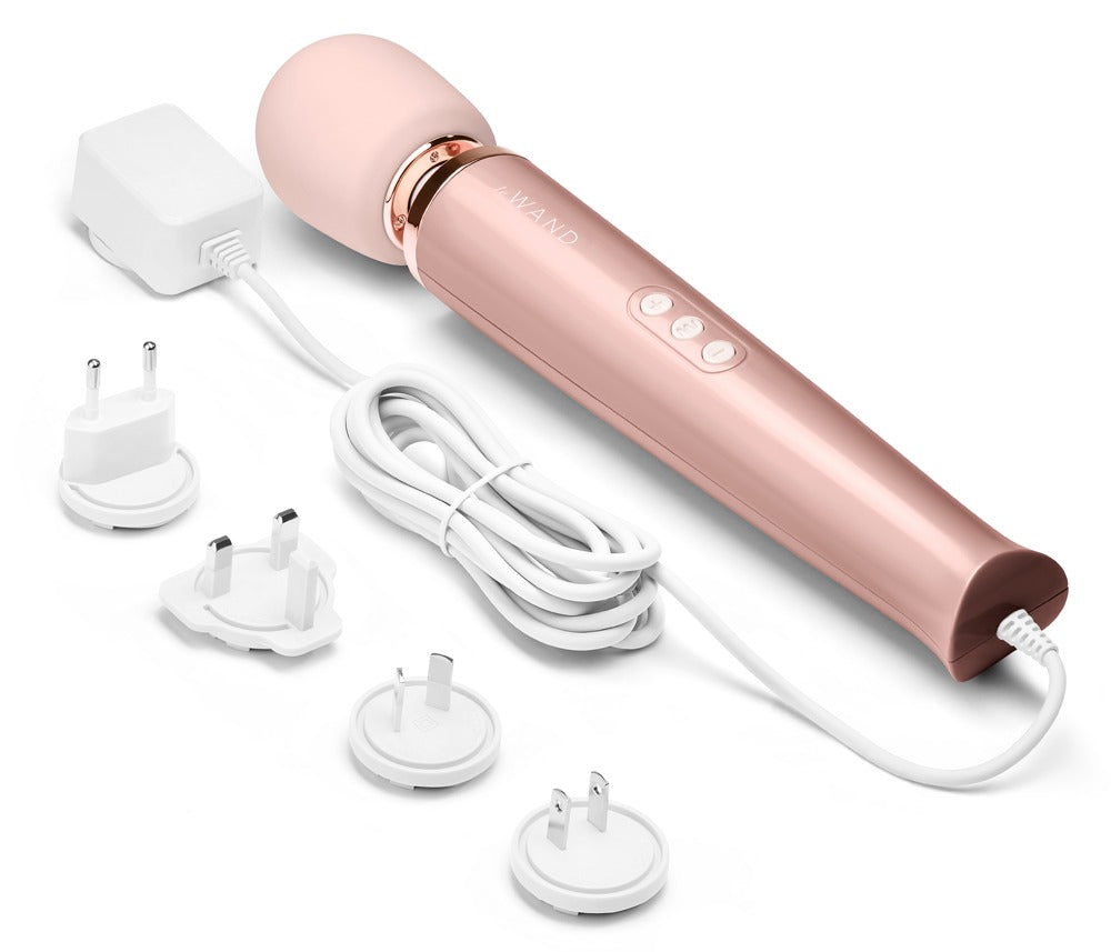 le WAND Powerful Plug-In Massagestab in Roségold mit rosafarbenem Massagekopf und mehreren abgebildeten Massageaufsätzen in einer Produktübersicht – erhältlich bei Evoria Care