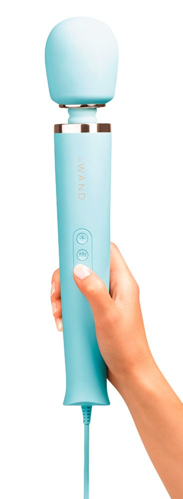 le WAND Powerful Plug-In Massagestab in Türkis mit goldfarbenen Akzenten, aufrecht in einer Hand gehalten zur Veranschaulichung von Größe und Handhabung – erhältlich bei Evoria Care