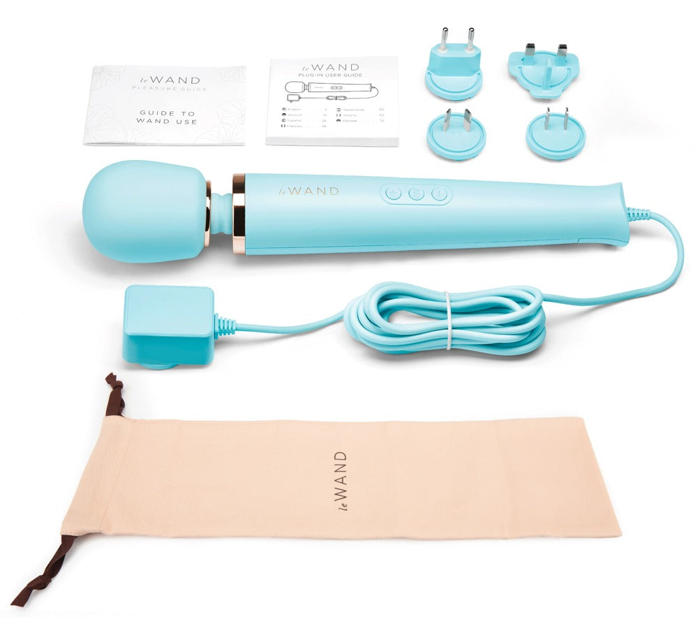 le WAND Powerful Plug-In Luxus-Massagestab in Türkis mit verschiedenen Massageaufsätzen, Anschlusskabel und beigefarbenem Aufbewahrungszubehör – erhältlich bei Evoria Care