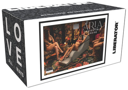 Liberator Aria Flip Chaise Premium-Sexlounge in grauer Ausführung, dargestellt auf der schwarz gestalteten Originalverpackung mit Produktabbildung, Anwendungsmotiv und Liberator Markenlogo – erhältlich bei Evoria Care
