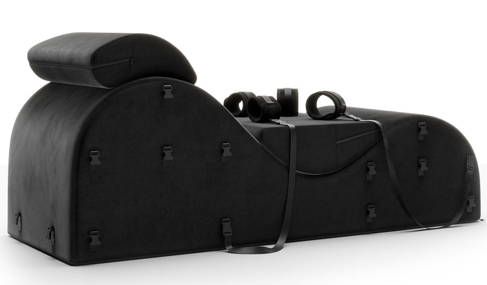 Liberator Black Label Esse – schwarze ergonomische Bondage-Lounge mit gepolsterten Stützkissen, seitlich verlaufenden Fixiergurten und sichtbaren Befestigungselementen in seitlicher Produktansicht auf weißem Hintergrund – erhältlich bei Evoria Care