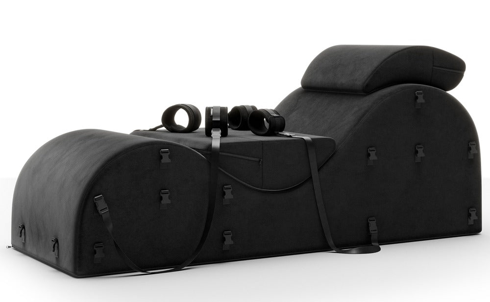 Liberator Black Label Esse – schwarze Premium-Bondage-Lounge mit ergonomisch geschwungener Liegefläche, zwei zusätzlichen Stützkissen, verstellbaren Fixiergurten und Metallringen in seitlicher Gesamtansicht auf weißem Hintergrund – erhältlich bei Evoria Care