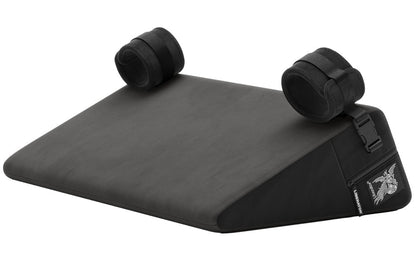 Liberator Bondage Wedge – schwarzes keilförmiges Premium-Liebeskissen mit glatter Liegefläche, zwei gepolsterten Soft-Fesseln und seitlichem Liberator Markenetikett in schräger Produktansicht auf weißem Hintergrund – erhältlich bei Evoria Care