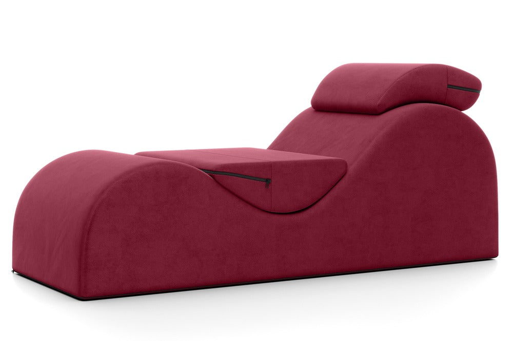 Liberator Esse Lounger – bordeauxrotes Premium-Sexmöbel mit ergonomisch geschwungener Liegefläche, erhöhten Polsterbereichen und zwei zusätzlichen Stützkissen in seitlicher Gesamtansicht auf weißem Hintergrund – erhältlich bei Evoria Care
