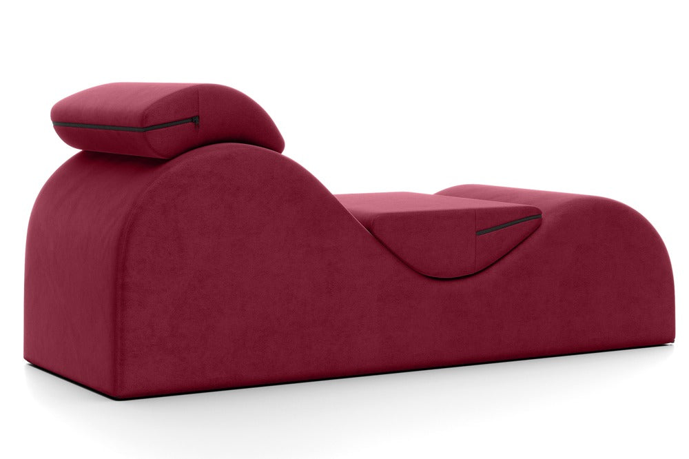 Liberator Esse Lounger – bordeauxrote ergonomische Sex-Lounge mit geschwungenem Polsterkörper, erhöhtem Liegebereich und zwei aufliegenden Stützkissen in schräger Produktansicht auf weißem Hintergrund – erhältlich bei Evoria Care